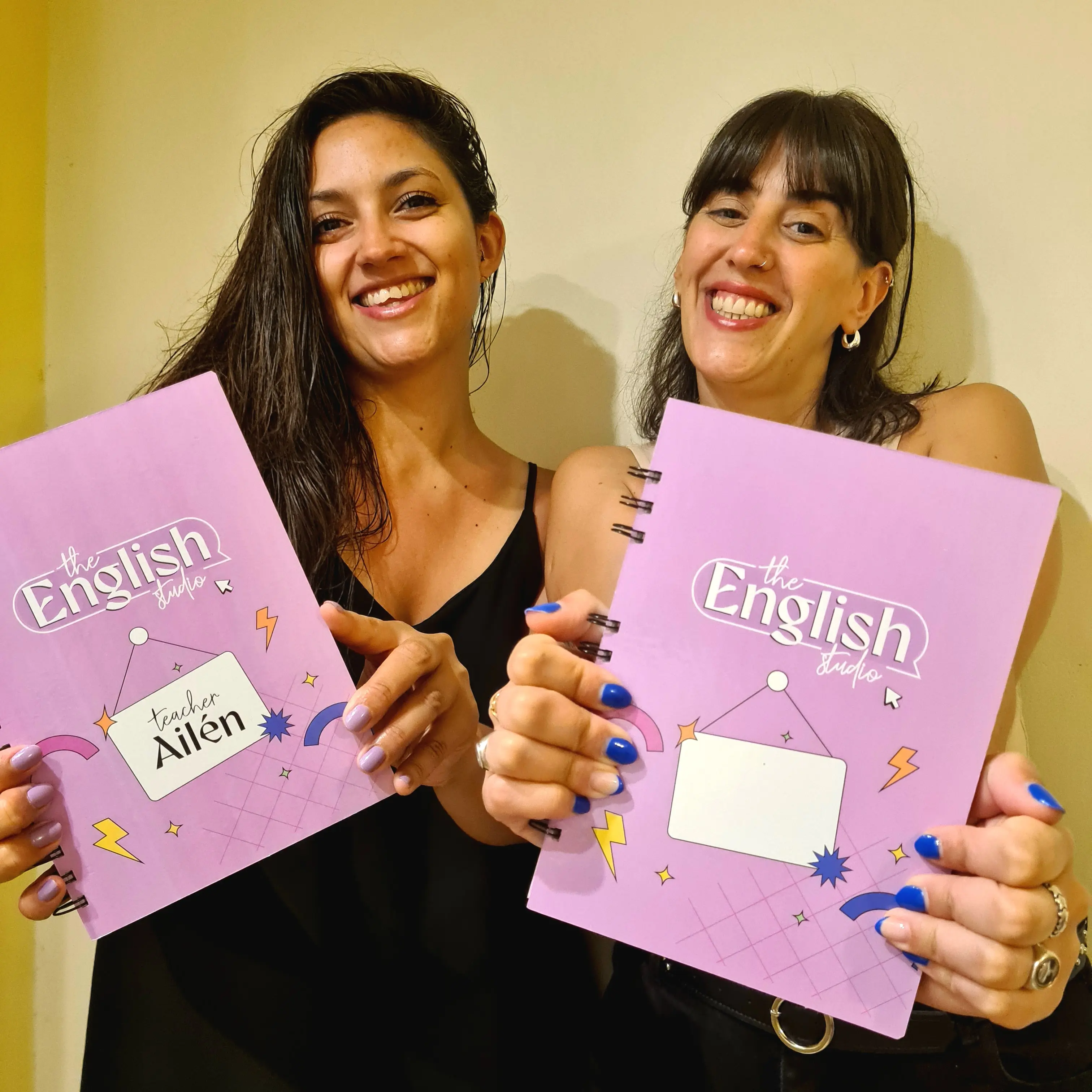 Ailén y Agostina sonriendo con un libro de TES